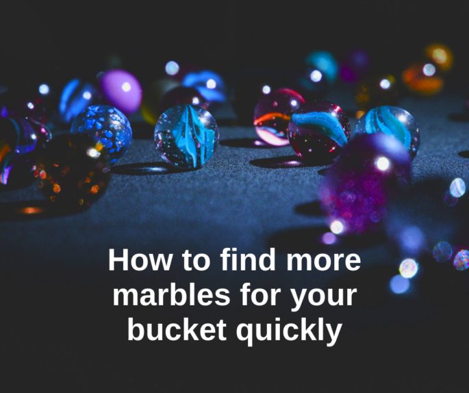 Marbles on a blue surface with the text "How to find more marbles for your bucket quickly"